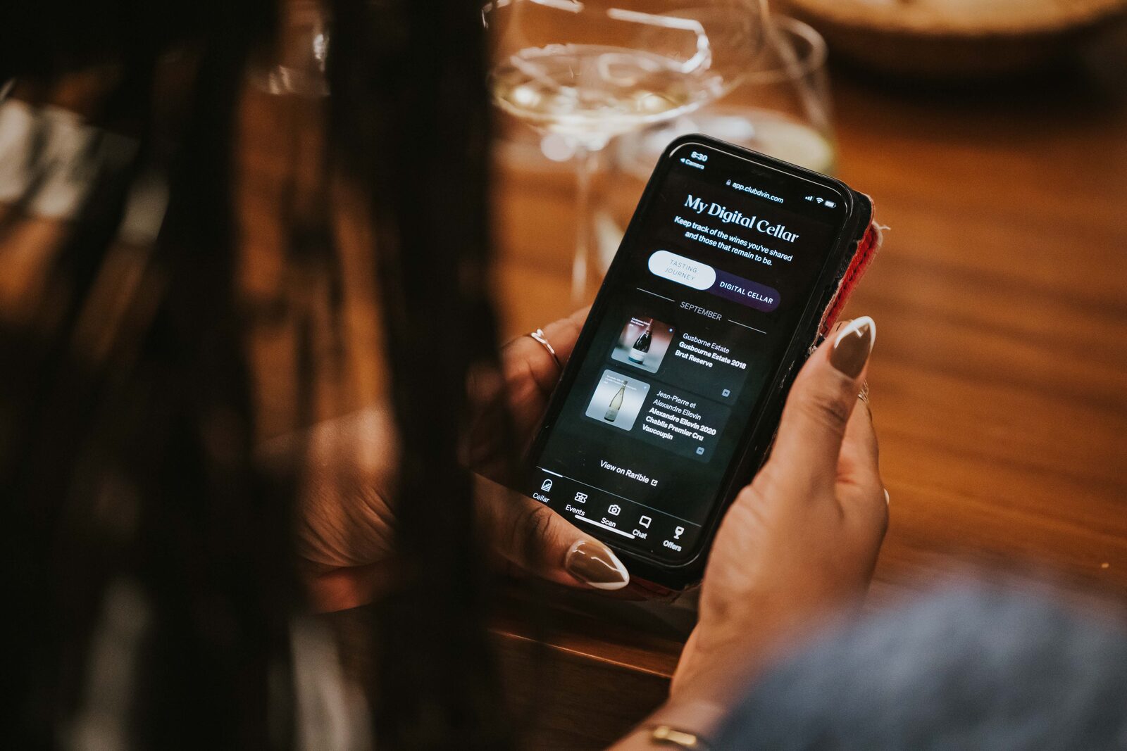 A Club dVIN member viewing their digital cellar on the app, browsing their wines and provenance records